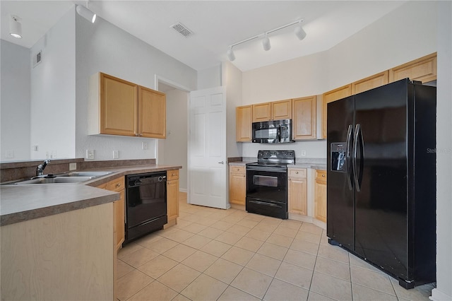 kitchen featuring light brown cabinetry, sink, and black appliances