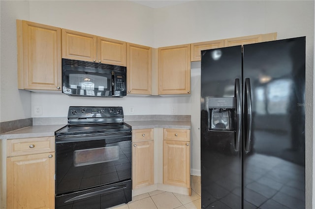 kitchen with light brown cabinets, light tile patterned floors, and black appliances