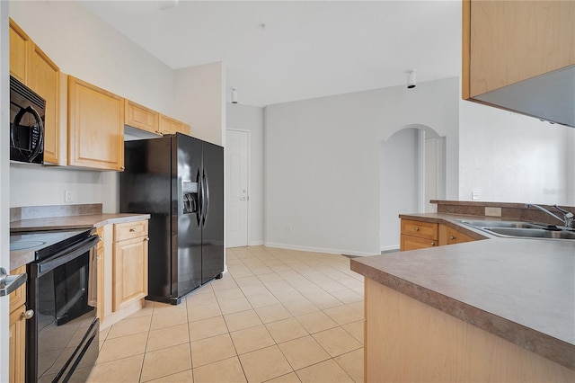 kitchen featuring black appliances, light brown cabinetry, and light tile patterned floors