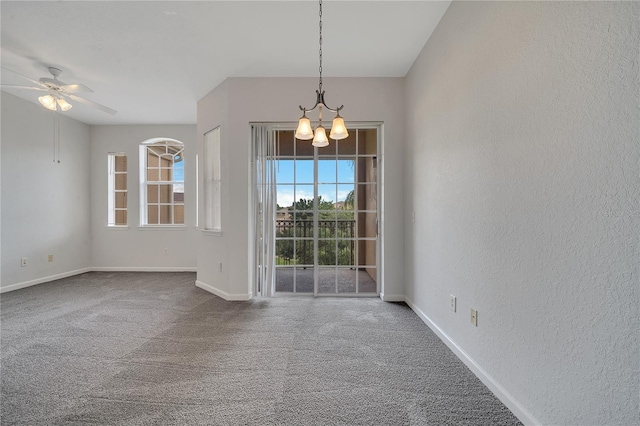 carpeted empty room featuring ceiling fan with notable chandelier