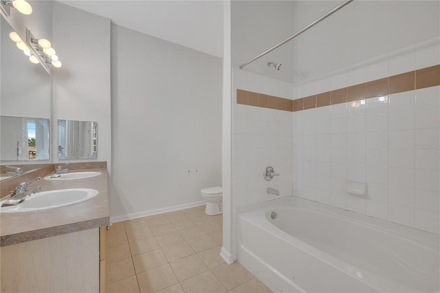 full bathroom featuring tiled shower / bath, vanity, toilet, and tile patterned floors