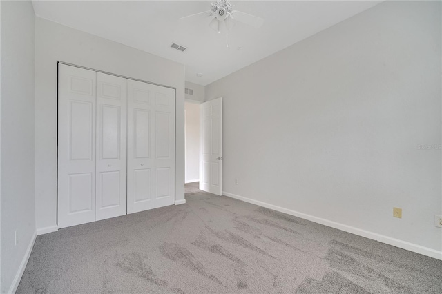 unfurnished bedroom featuring a closet, ceiling fan, and light colored carpet