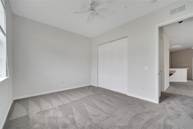 unfurnished bedroom featuring carpet, ceiling fan, and a closet