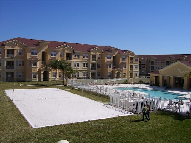 view of swimming pool with a lawn and volleyball court