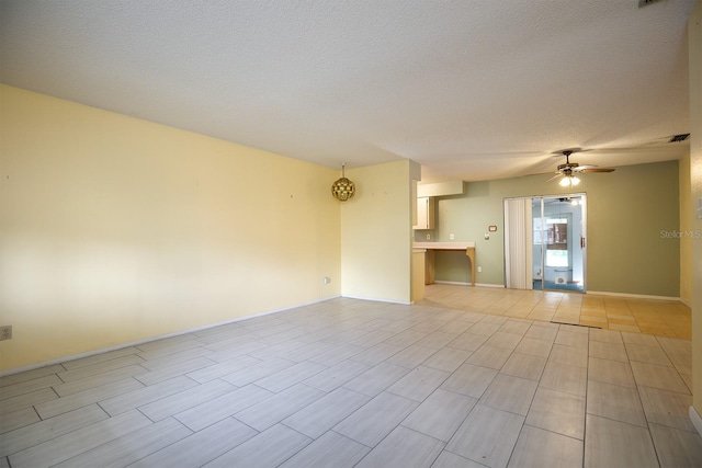 spare room with a textured ceiling, light wood-type flooring, and ceiling fan