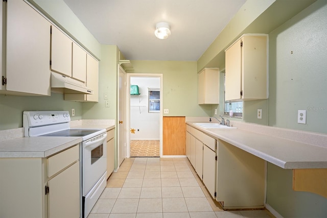 kitchen featuring white range with electric cooktop, light tile patterned floors, and sink