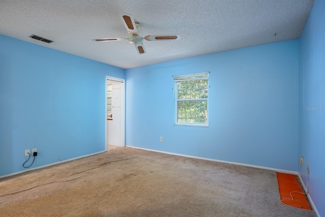 carpeted spare room featuring a textured ceiling and ceiling fan