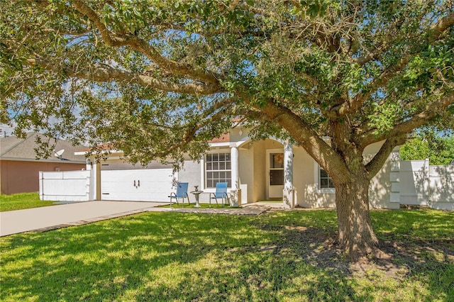 view of property hidden behind natural elements featuring a front yard and a garage