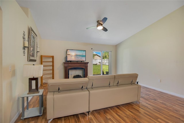 living room with ceiling fan, hardwood / wood-style flooring, and lofted ceiling