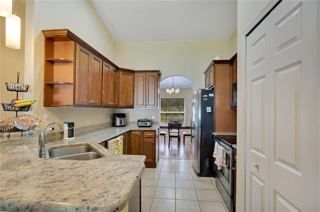 kitchen with kitchen peninsula, hanging light fixtures, light tile patterned flooring, stainless steel appliances, and sink