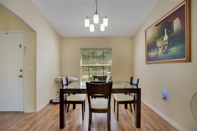 dining room with hardwood / wood-style floors and a notable chandelier