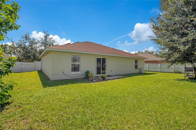 rear view of property featuring a lawn