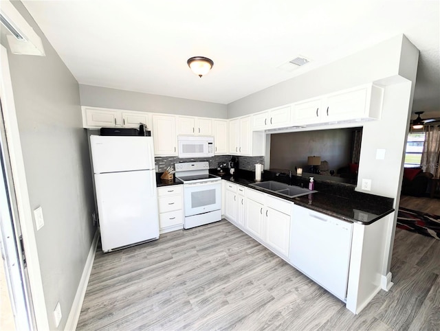 kitchen with white appliances, white cabinets, sink, decorative backsplash, and light hardwood / wood-style floors