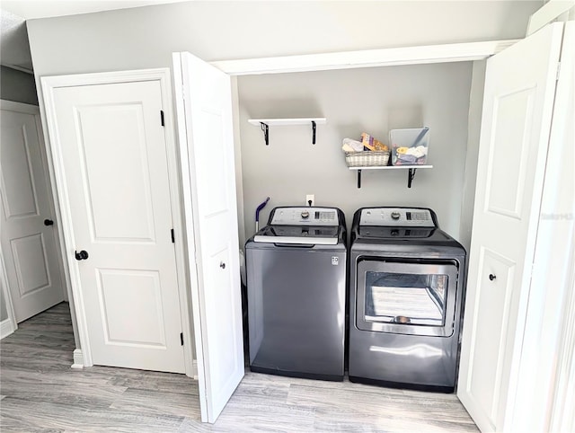 laundry room featuring washer and clothes dryer and light hardwood / wood-style floors