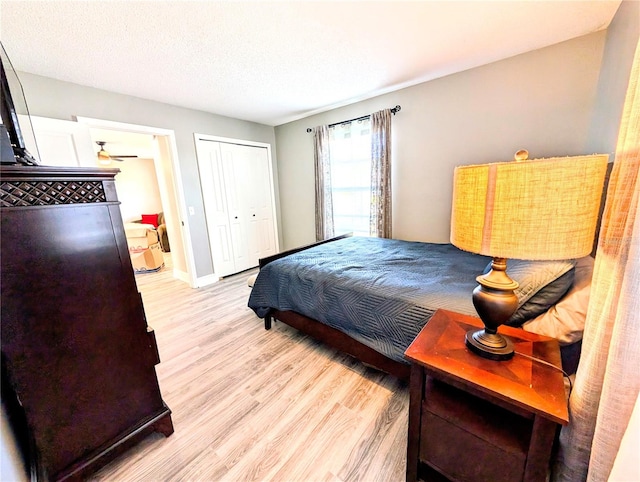 bedroom featuring a closet, a textured ceiling, and light wood-type flooring