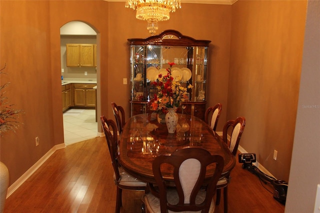 dining area featuring crown molding, hardwood / wood-style floors, and an inviting chandelier