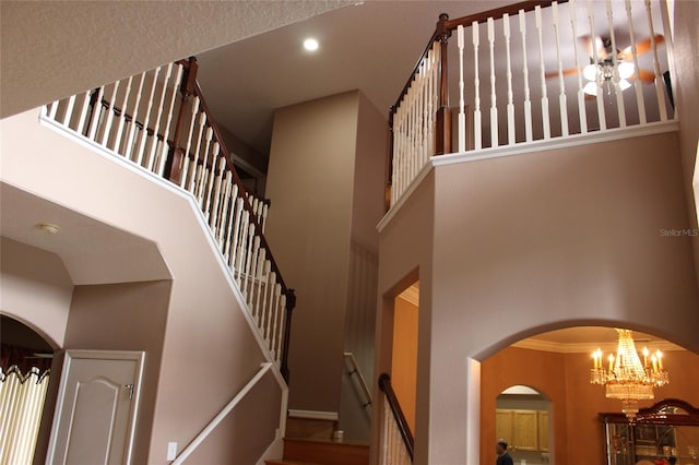 staircase featuring crown molding and a towering ceiling