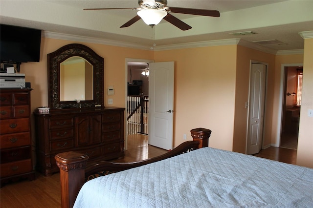 bedroom with ornamental molding, ceiling fan, and dark hardwood / wood-style flooring