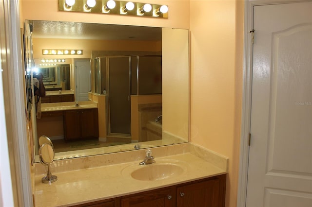 bathroom with a shower with door and vanity