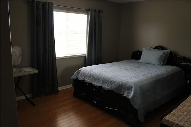 bedroom with dark hardwood / wood-style flooring