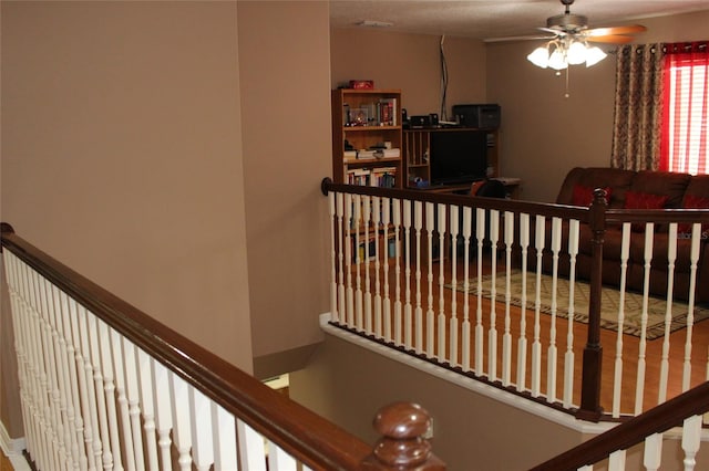 stairway with ceiling fan and hardwood / wood-style floors