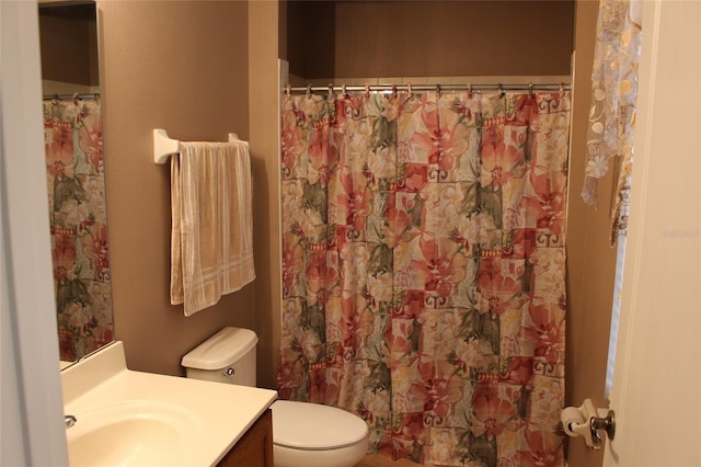 bathroom with a shower with shower curtain, vanity, and toilet