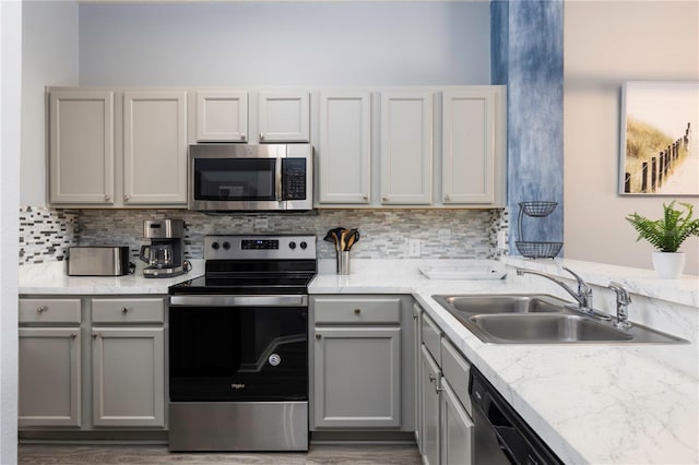 3052 Secret Lake Dr, Kissimmee, FL 34747 - kitchen featuring stainless steel appliances, gray cabinets, backsplash, and wood finished floors