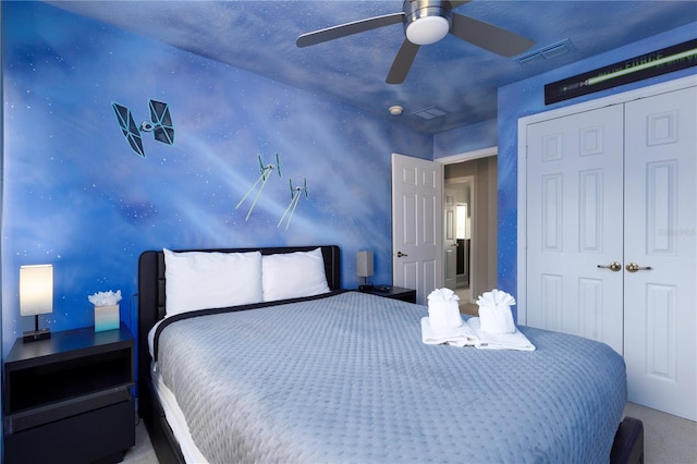 carpeted bedroom featuring ceiling fan and a closet