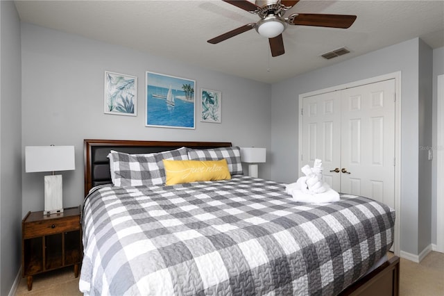 carpeted bedroom featuring a textured ceiling, ceiling fan, and a closet