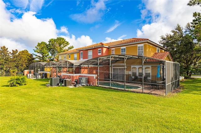 back of property with cooling unit, a yard, and glass enclosure