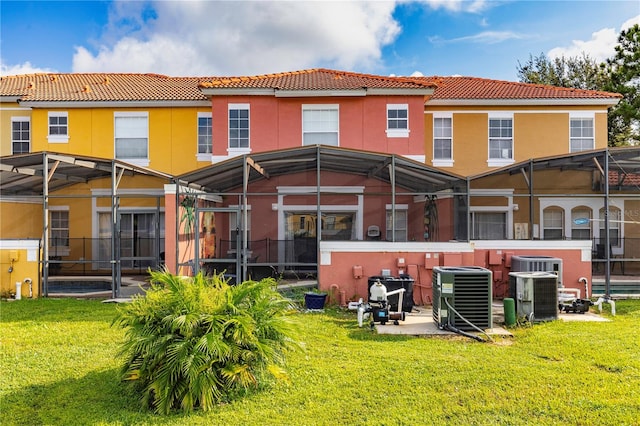 back of house featuring glass enclosure, a yard, a patio, and central AC