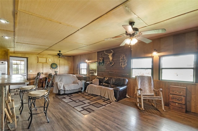 living room with ceiling fan, hardwood / wood-style floors, wooden ceiling, and wood walls