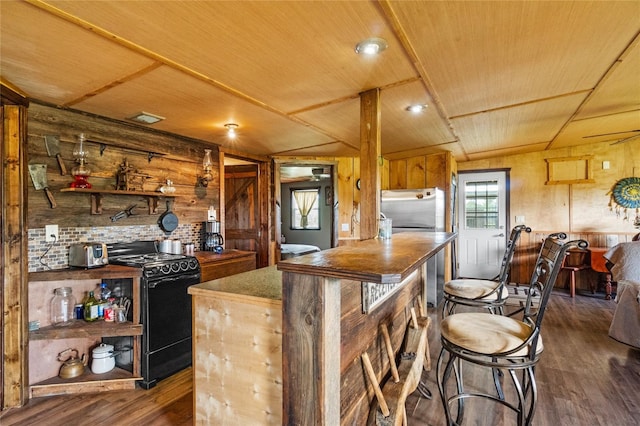 kitchen with wood walls, dark wood-type flooring, black electric range oven, and wooden ceiling