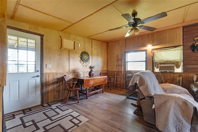 interior space featuring ceiling fan, wood walls, wood-type flooring, and wooden ceiling