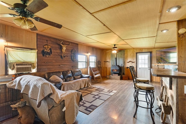 living room featuring hardwood / wood-style flooring, wood ceiling, cooling unit, and wood walls