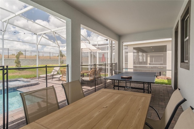 sunroom featuring a jacuzzi and outdoor dining area