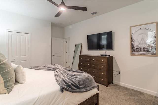 bedroom with visible vents, baseboards, a closet, ceiling fan, and light colored carpet