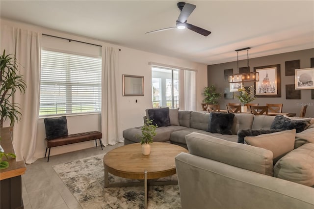 living room featuring ceiling fan with notable chandelier