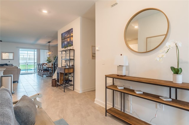 hall featuring light tile patterned floors and baseboards