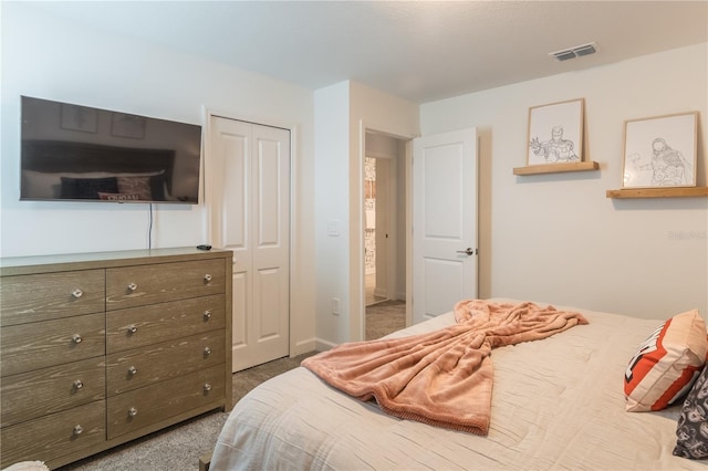 carpeted bedroom featuring a closet and visible vents