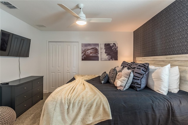 carpeted bedroom featuring visible vents, ceiling fan, and a closet
