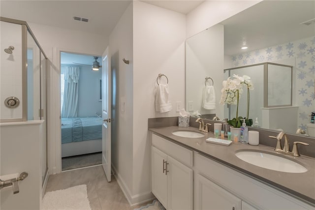 full bath with a shower stall, double vanity, a sink, and visible vents