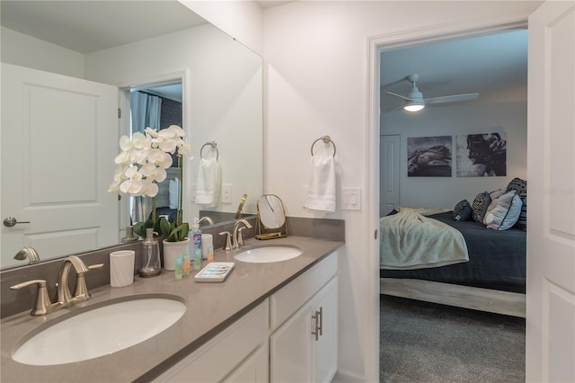 full bathroom featuring double vanity, ensuite bath, a sink, and a ceiling fan