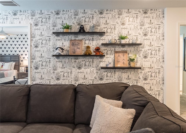 living area featuring visible vents and wallpapered walls
