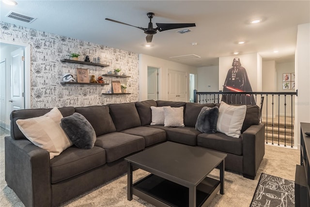living room with wallpapered walls, light colored carpet, a ceiling fan, and visible vents