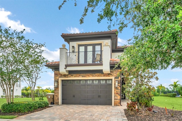 mediterranean / spanish house featuring a front yard, a balcony, and a garage