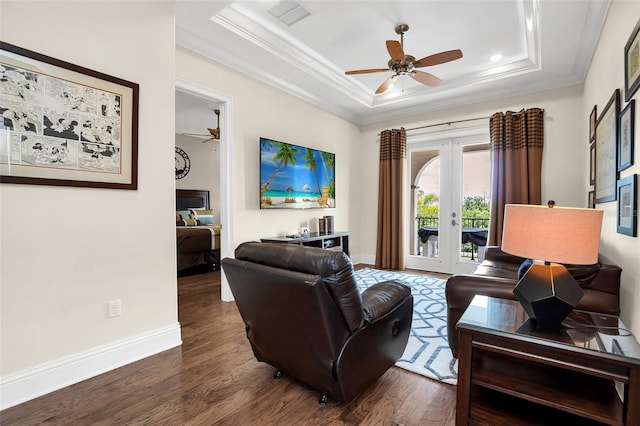 living room with crown molding, a tray ceiling, dark hardwood / wood-style flooring, and french doors