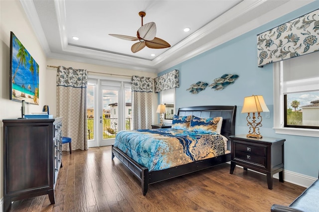 bedroom with ceiling fan, a raised ceiling, hardwood / wood-style flooring, crown molding, and access to exterior