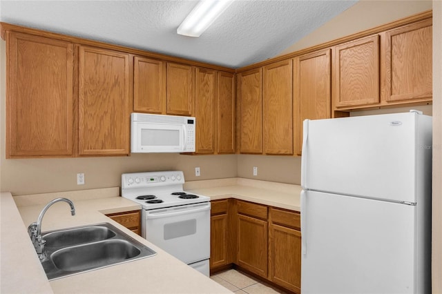 kitchen featuring white appliances, light tile patterned floors, a textured ceiling, lofted ceiling, and sink