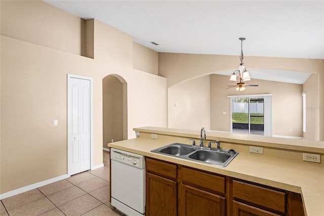 kitchen with white dishwasher, light tile patterned flooring, sink, decorative light fixtures, and vaulted ceiling